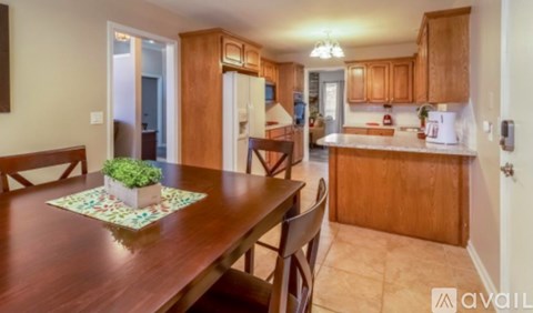 A kitchen with wooden cabinets and a table with a potted plant on it.