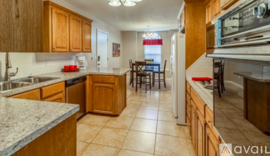 A kitchen with wooden cabinets and a marble countertop.