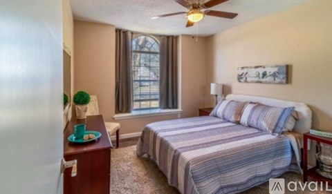 A bedroom with a bed, nightstand, and window.