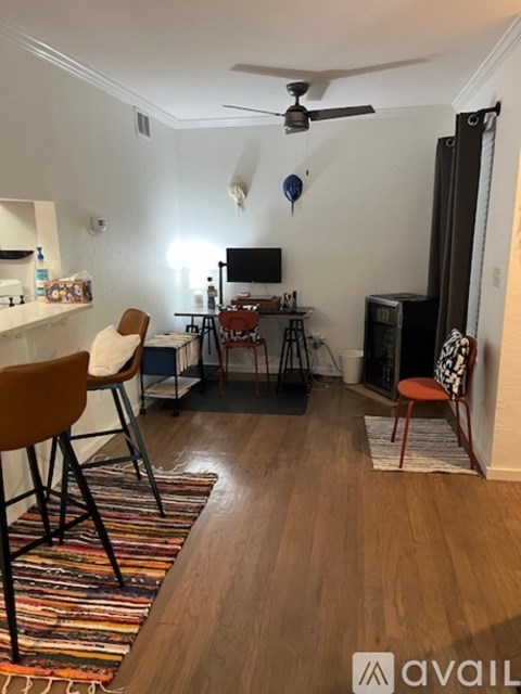 A living room with a brown chair and a black fan.