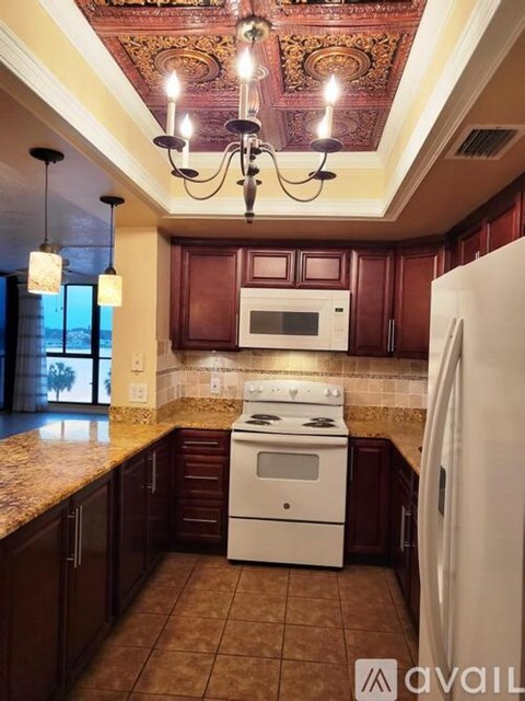 A kitchen with a white stove and a chandelier.