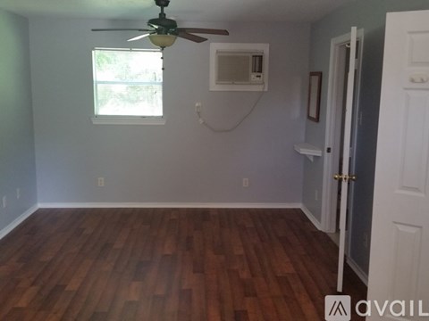A room with wood flooring and a ceiling fan.