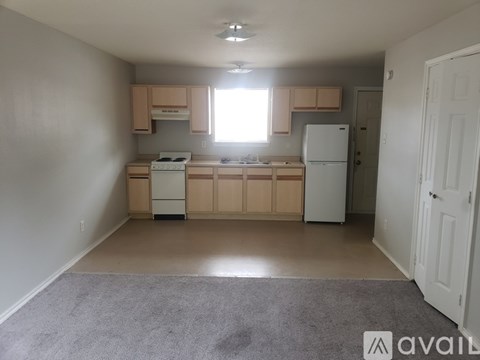 A kitchen with white appliances and wooden cabinets.