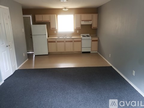 A kitchen with white appliances and a window.