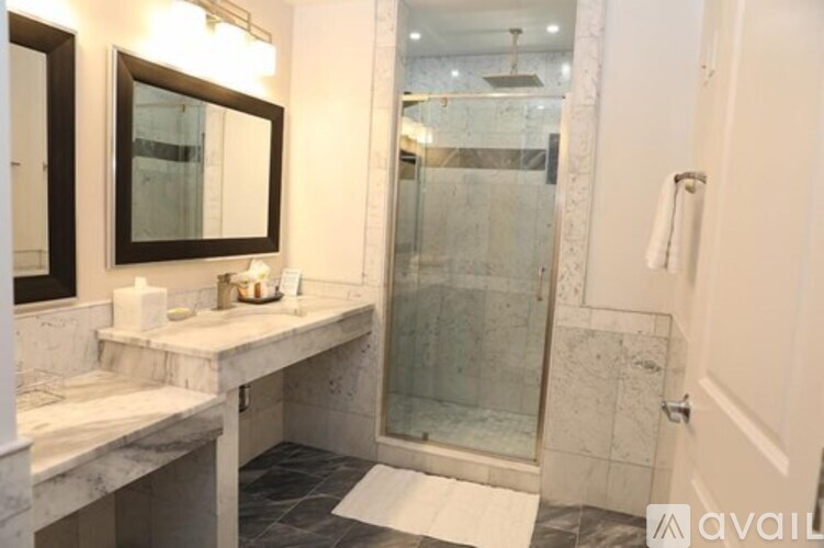 A bathroom with a marble countertop and a walk-in shower.