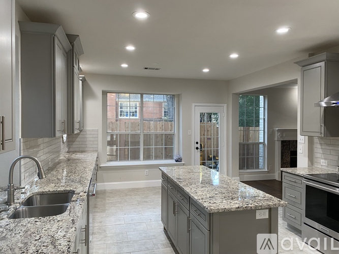 A modern kitchen with granite countertops and stainless steel appliances.