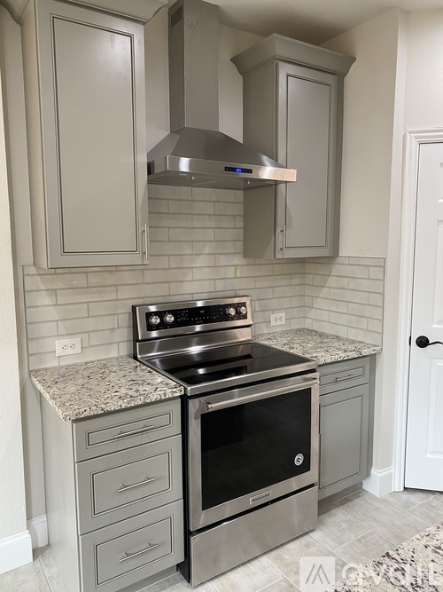 A modern kitchen with a stainless steel oven and cabinets.