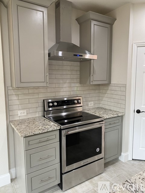 A modern kitchen with a stainless steel oven and cabinets.