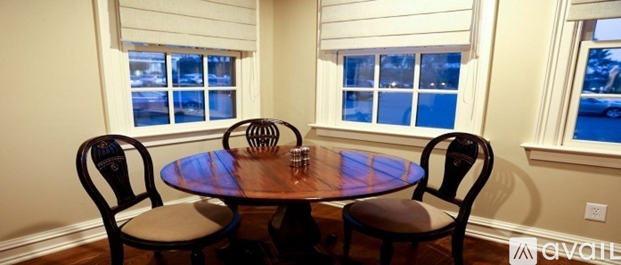 A table with two chairs in front of a window.