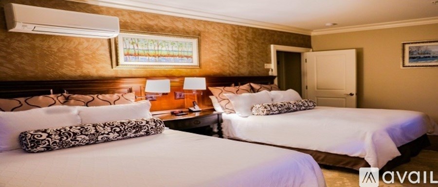 Two beds in a room with a painting on the wall.