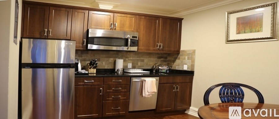 A kitchen with wooden cabinets and a stainless steel refrigerator.