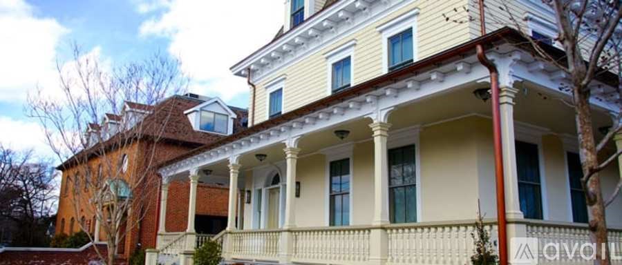 A white house with a red roof and a balcony.