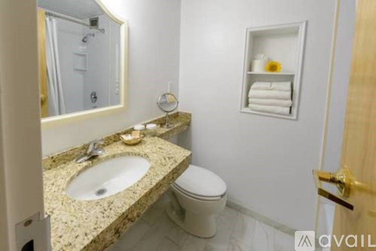 A bathroom with a sink, toilet, and mirror.