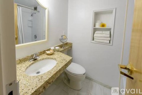 A bathroom with a sink, toilet, and mirror.