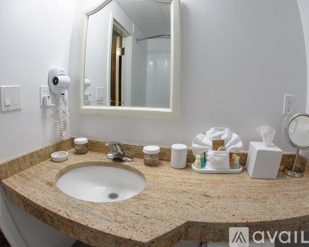 A bathroom sink with a mirror above it and a towel on the counter.