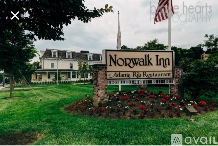 A sign for Norwalk Inn and Adam's Rib Restaurant is in front of a building.