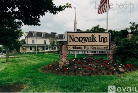 A sign for Norwalk Inn and Adam's Rib Restaurant is in front of a building.