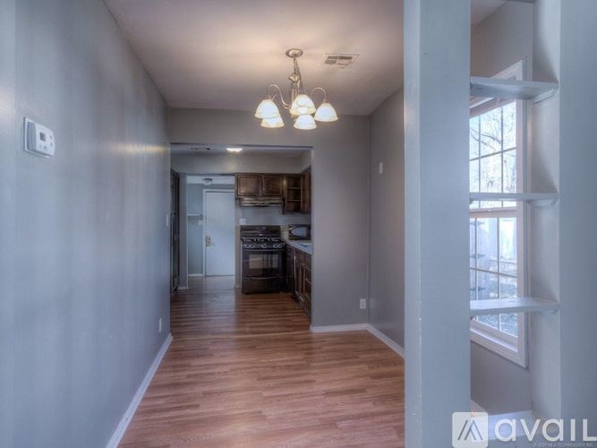 A long hallway with a kitchen area at the end.