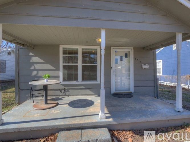 A small house with a porch and a table with chairs.