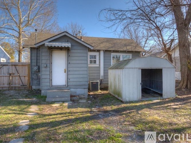 A house with a garage and a shed in front of it is for sale.