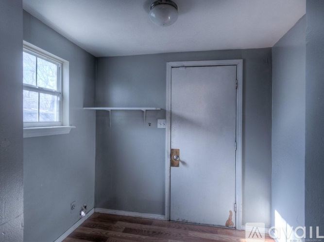 A room with a white door and a window.