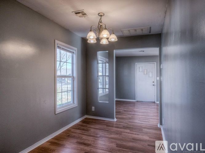 A room with wooden floors and a grey wall.