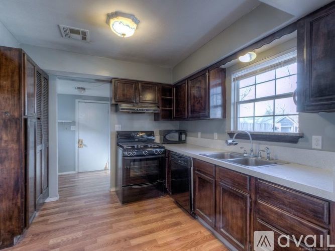 A kitchen with wooden cabinets and a stove top oven.