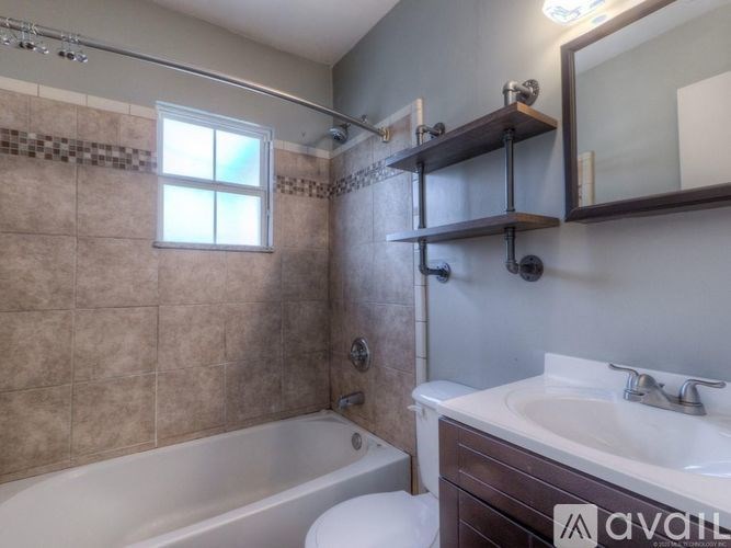 A bathroom with a tub, sink, and mirror.