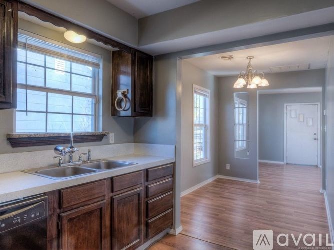 A kitchen with wooden cabinets and a stainless steel sink.