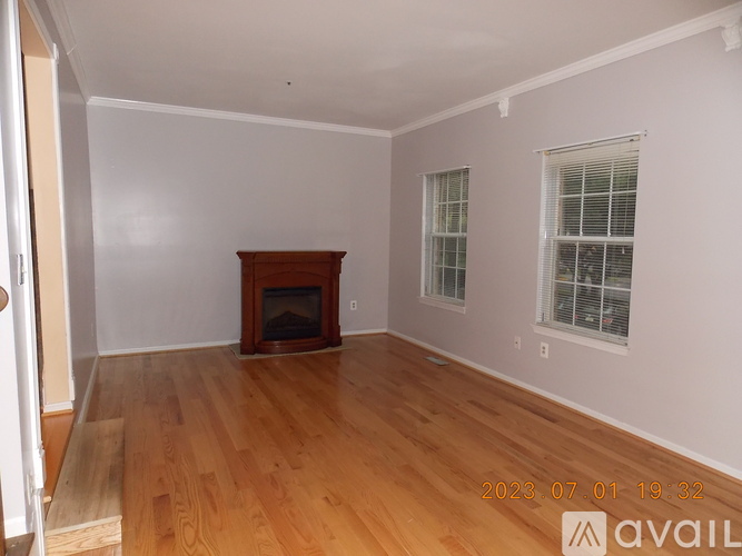 A room with a wooden floor and a fireplace.