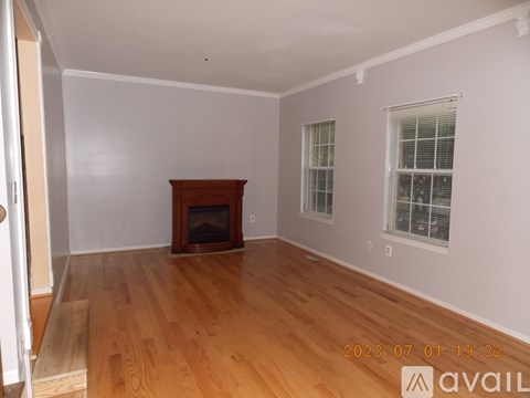 A room with a wooden floor and a fireplace.