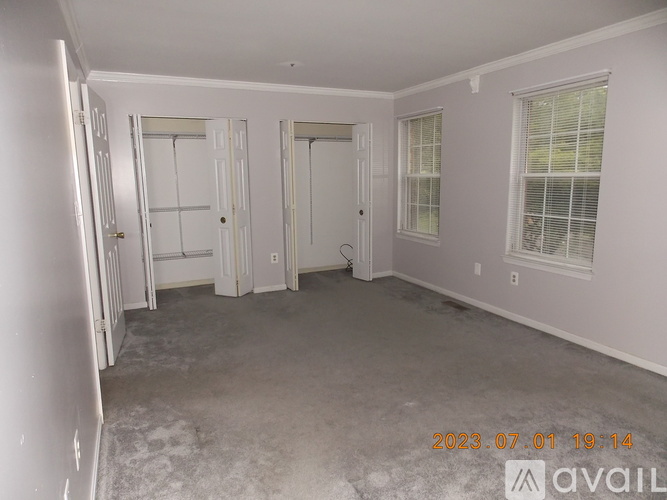 A room with white walls and a carpeted floor with a date stamp on the bottom right.