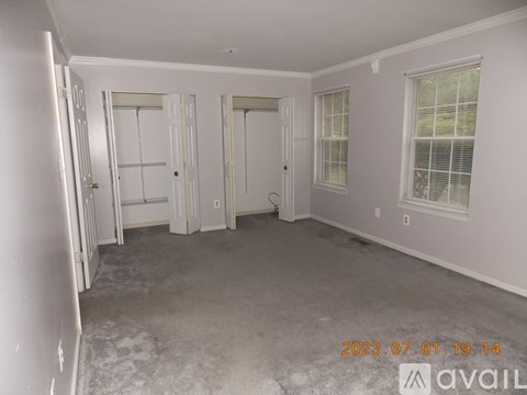 A room with white walls and a carpeted floor with a date stamp on the bottom right.