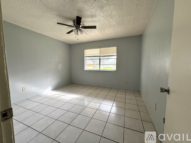 A room with a ceiling fan and a window.