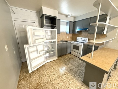 A kitchen with a refrigerator, stove, and oven.