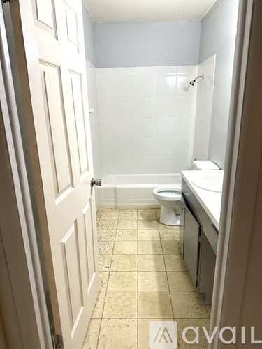 A bathroom with a toilet, sink, and shower.