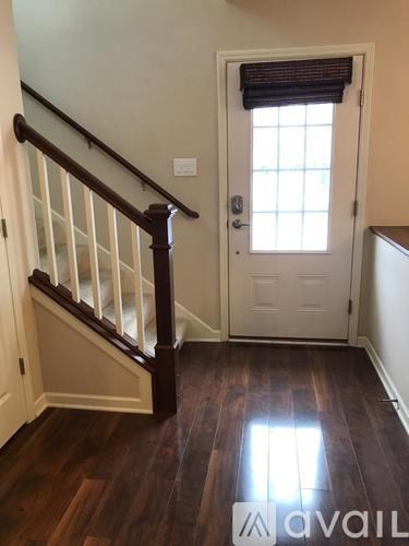 A hallway with a wooden floor and a white door.