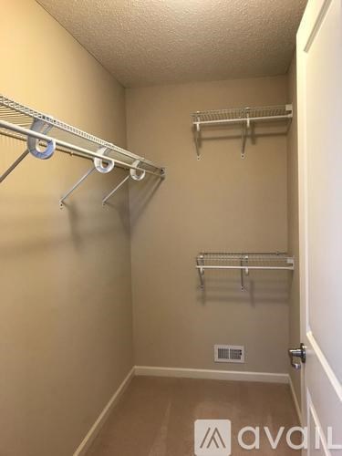 A small, empty closet with a white door and a white shelf.