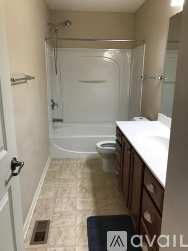 A bathroom with a toilet, sink, and shower.
