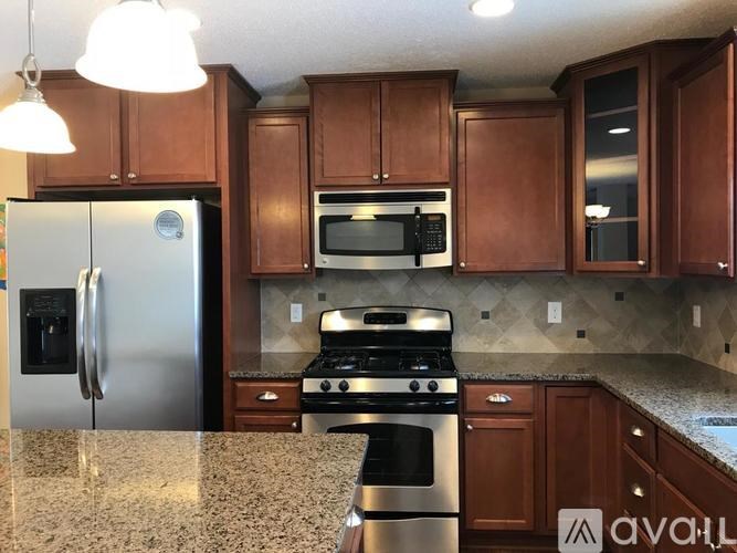 A kitchen with brown cabinets and a granite countertop.