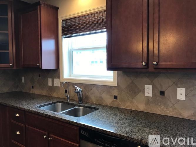 A kitchen with brown cabinets and a window above the sink.
