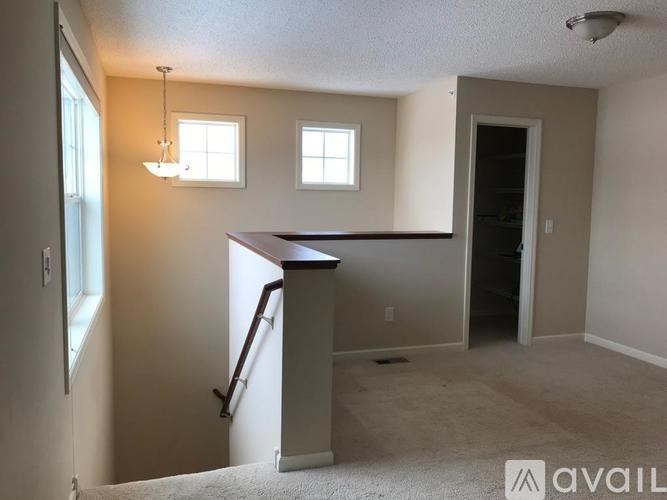 A room with a desk and two windows.