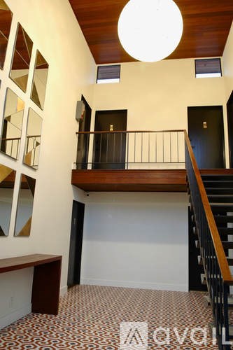A staircase with a wooden handrail and a tiled floor.