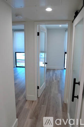 A hallway with a door on the right and a window on the left.