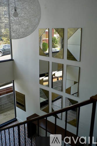 A hallway with mirrors on the wall and a staircase.