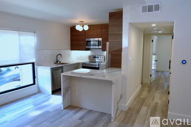 A kitchen with a white island and a window overlooking a street.