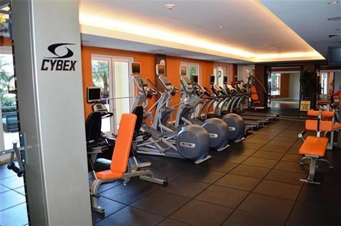 A gym with orange walls and a sign that says "CYBEX".