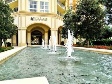 A fountain in front of a building with the name City Plaza on it.