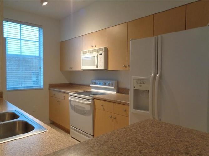 A kitchen with a sink, stove, and refrigerator.
