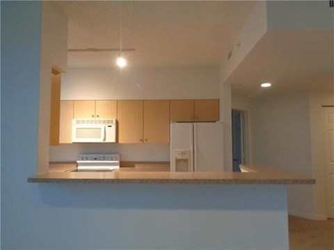 A kitchen with a microwave and oven built into the cabinetry.